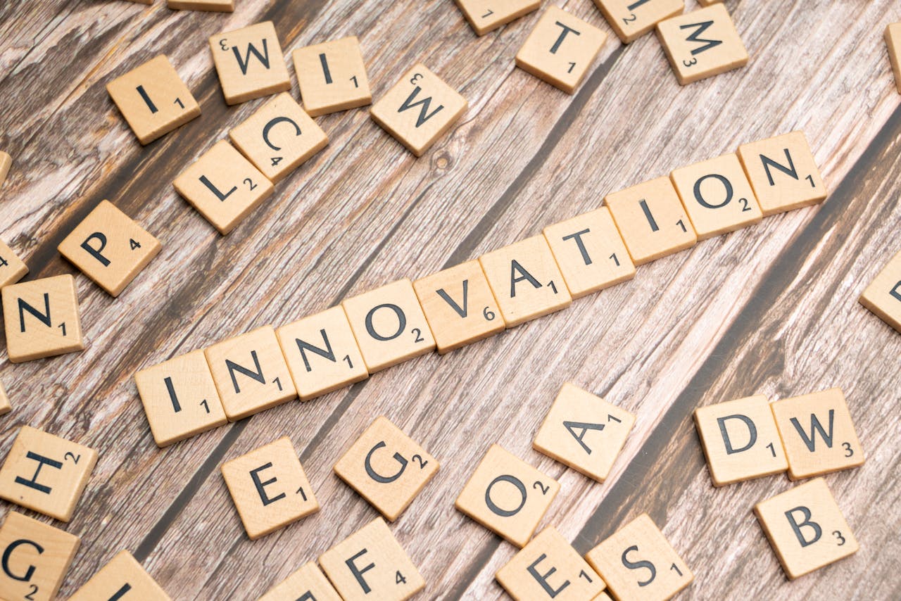 gallery-01 Creative display of 'Innovation' spelled with wooden letter tiles on a wooden surface.
